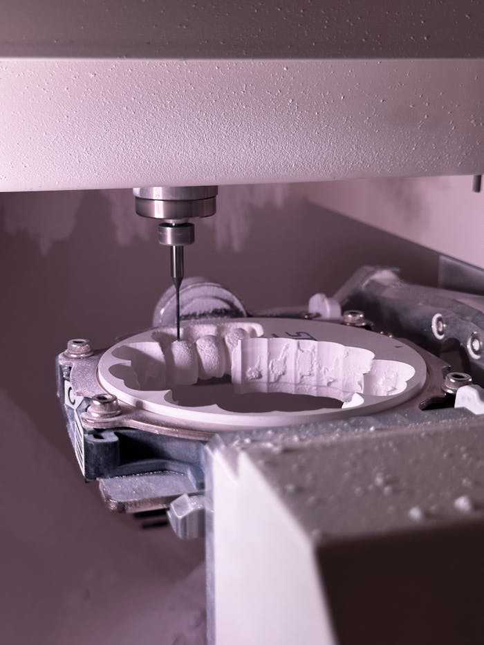Detailed view of CNC grinding machine shaping ceramic material with precision tool.